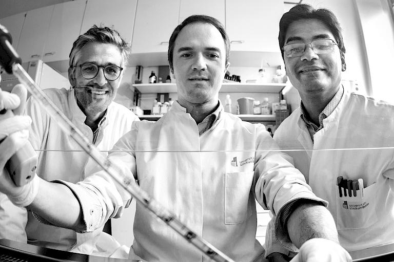 Drei Forscher des Herzzentrums bei der Arbeit mit einer Pipette und ein Bild einer Maschine mit mehreren Pipetten