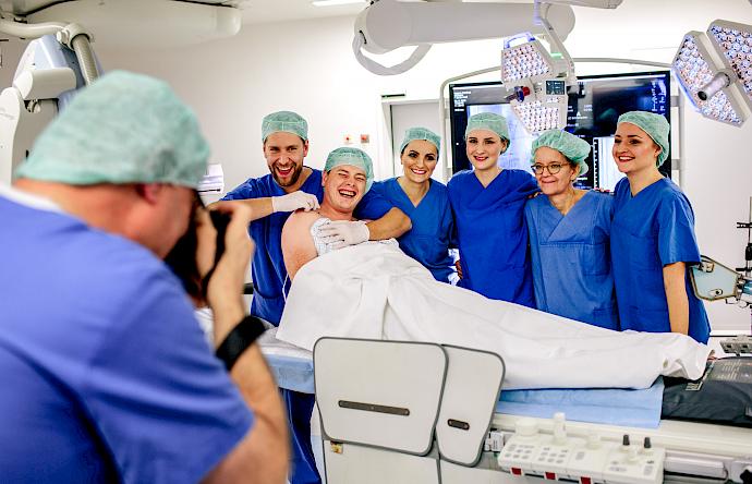 Bild von Personal und einem Patienten während einer Fotoaufnahme