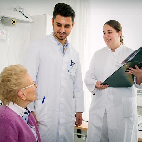 Bild von Ärzten bei der Visite einer Patientin