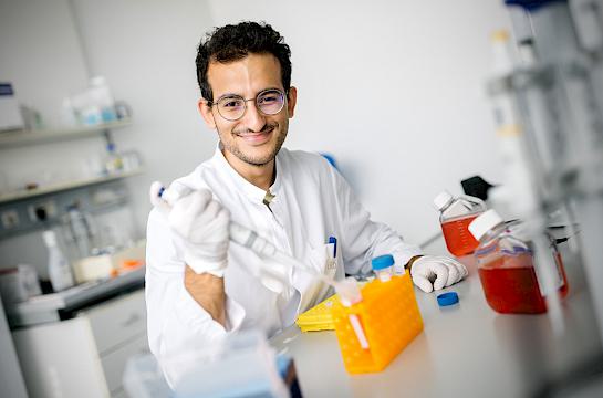 Drei Forscher des Herzzentrums bei der Arbeit mit einem Mikroskop